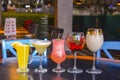 Cocktails on the table. Different coloured drinks in different glasses on dark wooden table Royalty Free Stock Photo