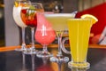 Cocktails on the table. Different coloured drinks in different glasses on dark wooden table Royalty Free Stock Photo