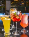 Cocktails on the table. Different coloured drinks in different glasses on dark wooden table Royalty Free Stock Photo