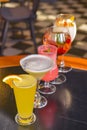 Cocktails on the table. Different coloured drinks in different glasses on dark wooden table. Royalty Free Stock Photo