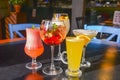 Cocktails on the table. Different coloured drinks in different glasses on dark wooden table Royalty Free Stock Photo