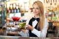 Cocktails for two. Attractive young woman working as a bartender holding a tray of cocktails. Royalty Free Stock Photo