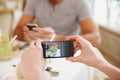 Cocktails She wants to share this pic with her friends. A woman taking a picture while dining out with her partner at a Royalty Free Stock Photo