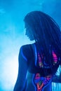 Cocky Girl with Dreadlocks in Ultraviolet neon light with Foggy Background. Bodyart