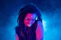 Cocky Girl with Dreadlocks in Ultraviolet neon light with Foggy Background. Bodyart