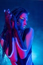 Cocky Girl with Dreadlocks in Ultraviolet neon light with Foggy Background. Bodyart