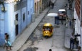 Coco Taxi moves down small street filled with people in Havana Royalty Free Stock Photo