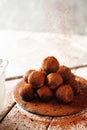 Cocoa balls, chocolate truffle cakes on a black slate tray, sprinkled with cocoa powder. Process of cooking
