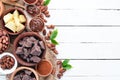 Cocoa beans, chocolate, cocoa butter and cocoa powder on a white wooden background. Top view. Royalty Free Stock Photo