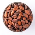 Cocoa beans in a round bowl on white background, top view. Vegan food ingredients