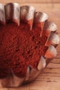 Cocoa beans in sieve with cocoa powder in tinware