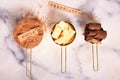 Cocoa, cocoa butter and cocoa beans, chocolate in gold containers on a marble surface. Flat lay. Place for text.