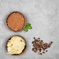 Cocoa butter, cocoa powder, mint and carob on gray stone background