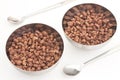 Cocoa coated puffed rice in metal bowls on white