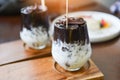 Cocoa drink and chocolate - tasty milk shake with ice cocoa in glass on wood background