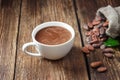 Cocoa drink in white mug and cocoa beans