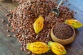 Cocoa nibs and cocoa fruit on wooden table