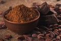 Cocoa powder in a brown ceramic bowl, raw cocoa beans in the pee