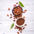 Cocoa powder and cacao beans on wooden background