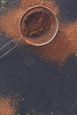 Cocoa powder in a sieve over black slate background Royalty Free Stock Photo