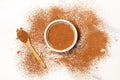 Cocoa powder in a white bowl, on a wooden spoon and on a marble kitchen counter Royalty Free Stock Photo