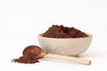 Cocoa powder in wooden bowl with wooden spoon