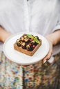 Cocoa tartalette with fresh seasonal berries in womans hands