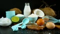 Coconut baking ingredients, coconut milk, flour, oil, and shredded coconut.