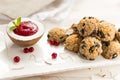 Coconut biscuits balls with cranberry sauce in coconut with mint on a white plate