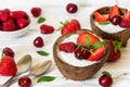 Coconut bowls with chia seeds pudding with berries, mint and spoons for healthy breakfast over white wooden table Royalty Free Stock Photo