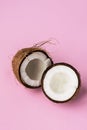 Coconut. Broken coconut on pink background.Two coconut halves. Copyspace