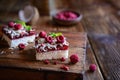 Coconut cake with raspberry layer and topped with white chocolate shavings and freeze - dried raspberries