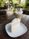 Coconut cake on white plate and cup of ice coffee Royalty Free Stock Photo