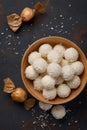 Coconut candies in bowl and wrapped in paper on dark table background Royalty Free Stock Photo