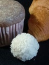 coconut candy, cupcake and croissant close-up on a black background Royalty Free Stock Photo