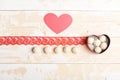 Coconut candy in a red heart on wooden background. Royalty Free Stock Photo