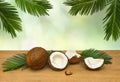 Coconut Cocos nucifera with half and palm leaves on wooden table
