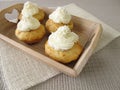 Coconut cupcakes with whipped cream on tray