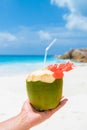 Coconut drink in palm hand on a tropical beach La Digue Seychelles Islands Royalty Free Stock Photo