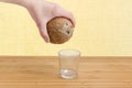 Coconut in hand over a glass on a wooden surface Royalty Free Stock Photo