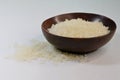 Coconut husk bowl filled with polished white Japanese short grain rice kernels, against white background Royalty Free Stock Photo