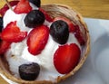 coconut ice-cream in coconut with strawberries and chocolate chips as topping