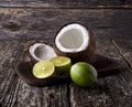 Coconut with limes on a wooden background