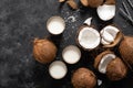 Coconut milk, whole and cracked coconuts on black background Royalty Free Stock Photo