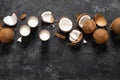 Coconut milk, whole and cracked coconuts on black background Royalty Free Stock Photo