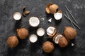 Coconut milk, whole and cracked coconuts on black background Royalty Free Stock Photo