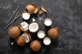 Coconut milk, whole and cracked coconuts on black background Royalty Free Stock Photo