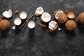 Coconut milk, whole and cracked coconuts on black background Royalty Free Stock Photo