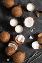 Coconut milk, whole and cracked coconuts on black background Royalty Free Stock Photo