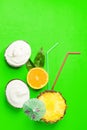 Coconut non-diary ice cream in shell bowls ripe juicy halved pineapple orange with leaves drinking straws cocktail umbrella on neo Royalty Free Stock Photo